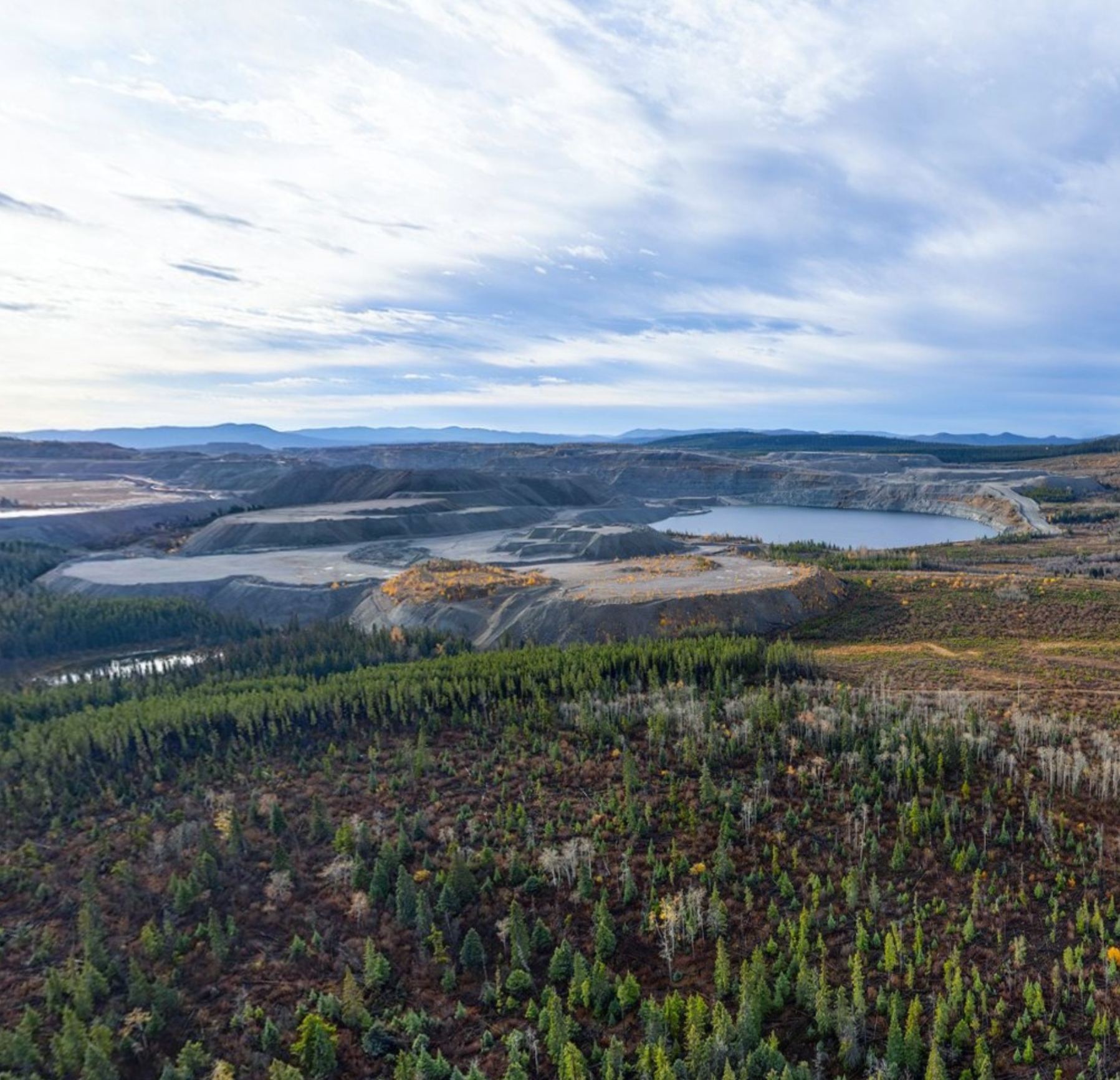 Three environmental technicians conducting environmental monitoring near a stream, measuring and recording data.