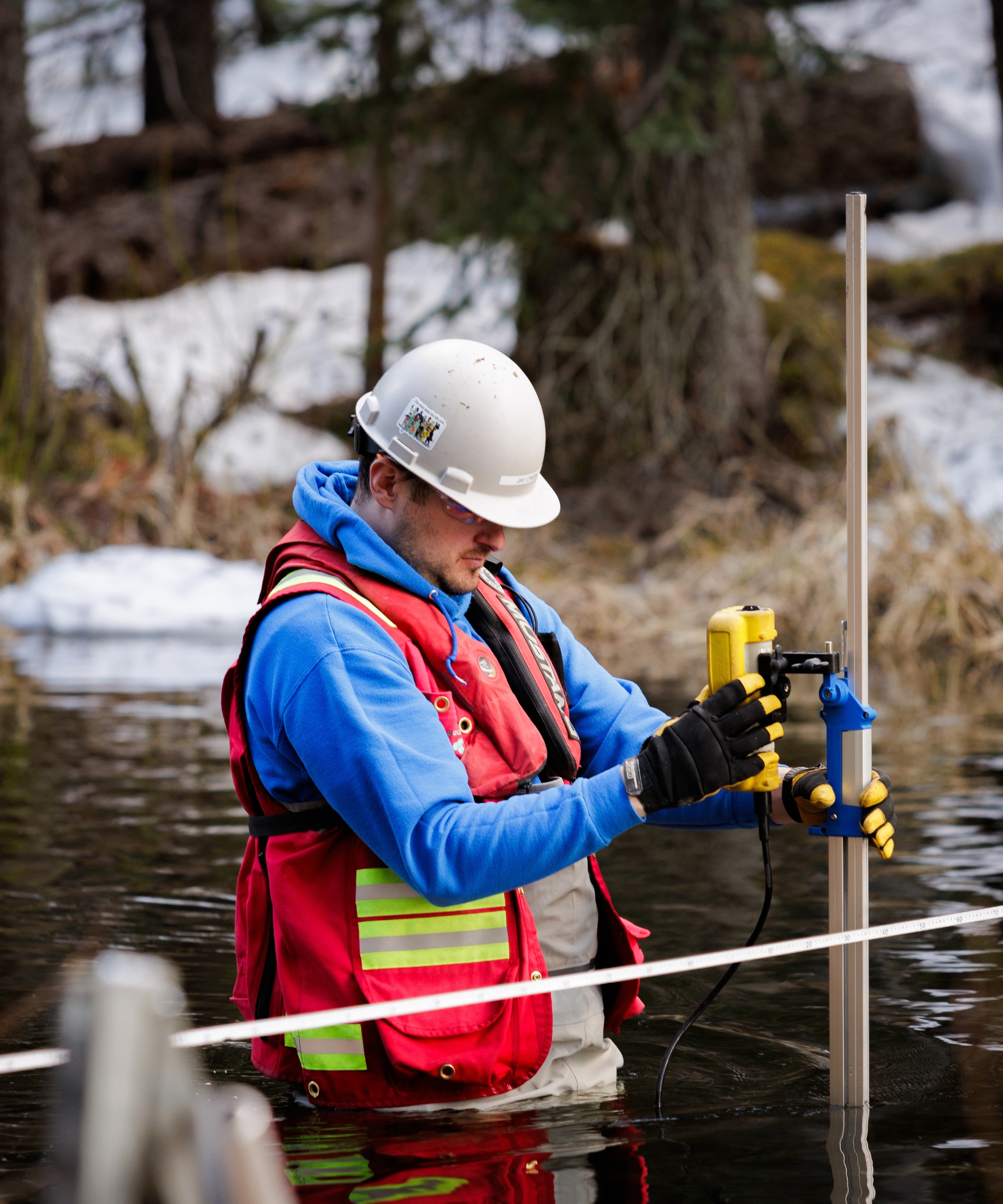 Three workers walking towards a wooded area, with vibrant autumn foliage filling the foreground