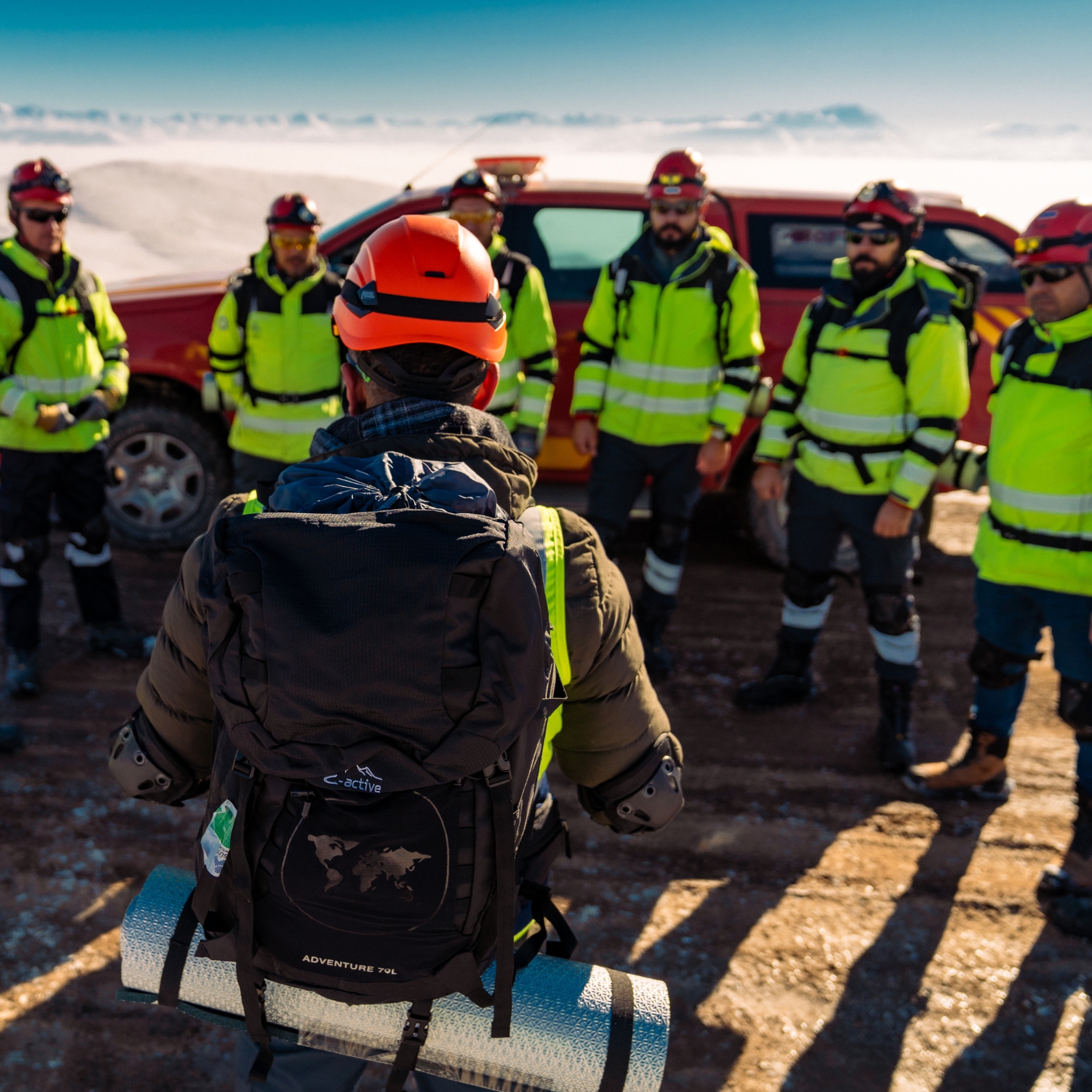Four women collaborating around a laptop in a modern office, smiling and engaging in discussion.