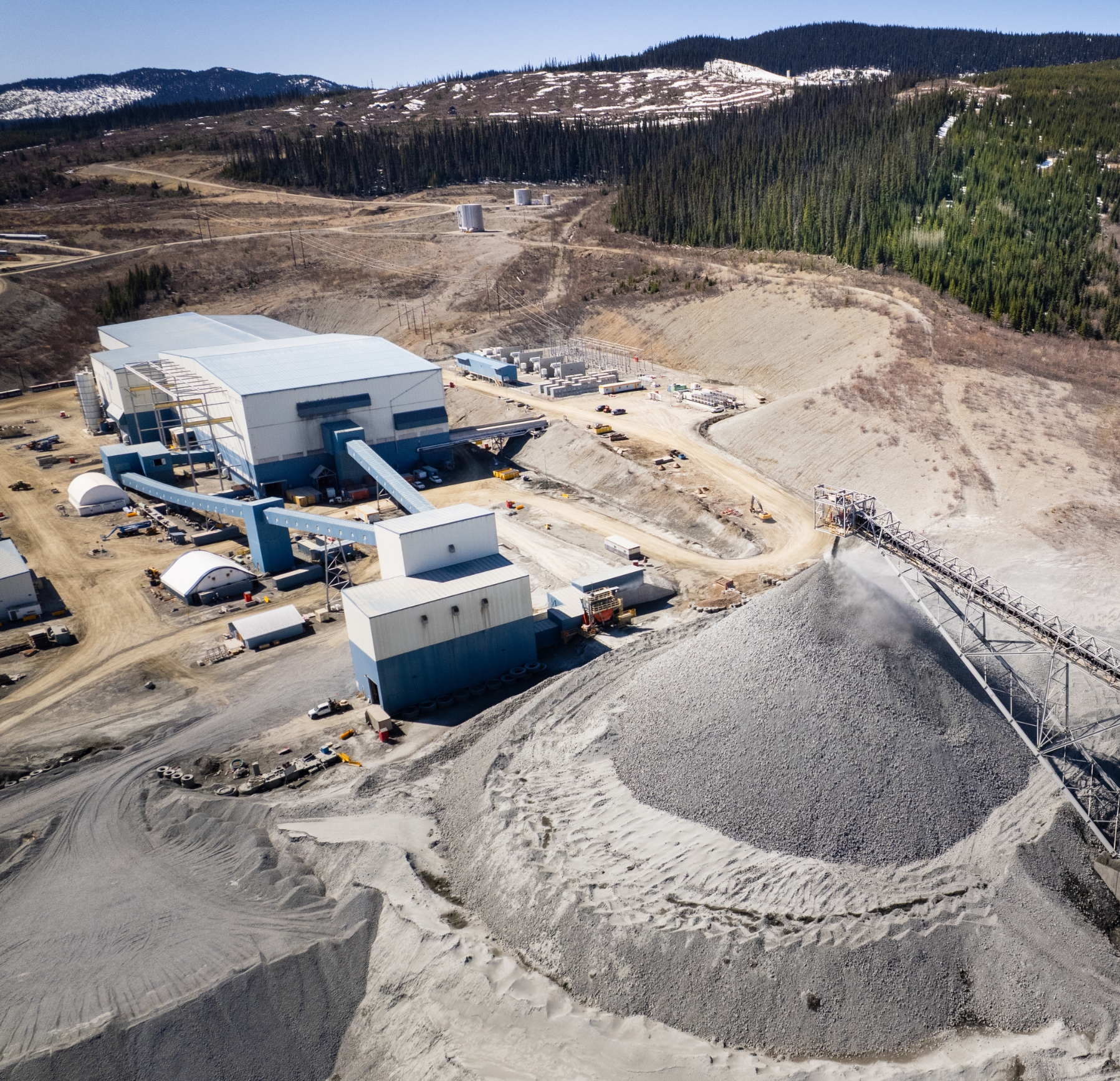 Two women sitting at a table, smiling at someone off-screen.