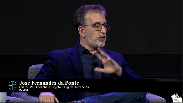 three people sitting in chairs on a stage at Consesnsus 2022