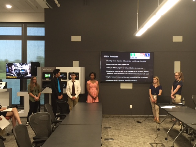 a group of people standing in front of a screen