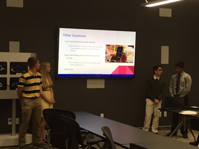 a group of people standing in front of a projector screen